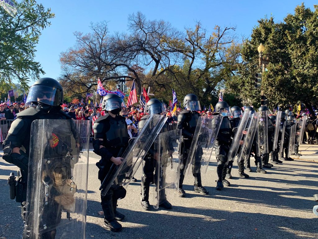 Police standing off with antifascists in front of the Million MAGA March.
